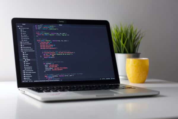 laptop with code on a wooden desk