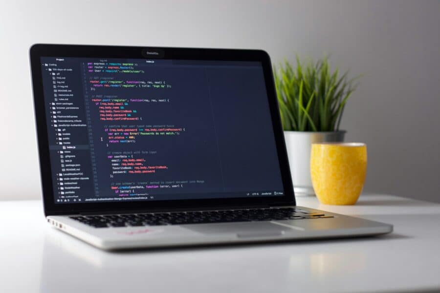 laptop with code on a wooden desk
